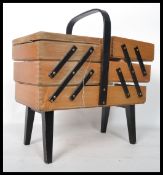 A vintage 20th century retro metamorphic sewing box having ebonised movements. The fold out sections
