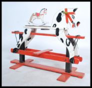 A mid 20th century retro child's rocking horse having handles to side raised on painted red supports