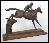 A good quality 20th century large bronzed resin sculpture of a steeplechase horse and jockey at a