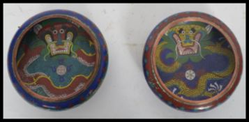 A pair of early 20th century circa 1900 Chinese cloisonne prayer bowls depicting dragons chasing the
