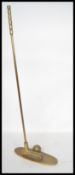 A 20th century brass golfing trophy door stop in the form of a golf ball and club. Measures 63 cm