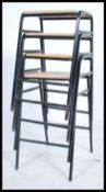 A set of four retro 20th century stacking lab / bar stools constructed with  ebonized tubular