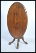A Victorian 19th century mahogany oval tilt top breakfast / loo table being raised on cabriole leg