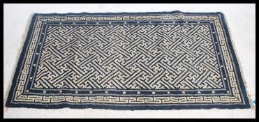 An early 20th century Tibetan chevron rug. The blue ground with white chevron design and tassled