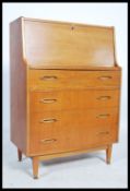 A retro 20th century teak wood bureau having a fall front with fully appointed interior over a