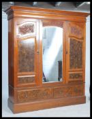 A good Edwardian walnut triple / large double wardrobe having a deep plinth drawer base with upright