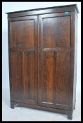 A 1920's oak bachelors compactum wardrobe. Raised on bracket feet with twin panel doors having a