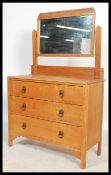 A 1920's light oak dressing chest of drawers. The chest with short and deep drawers having swing