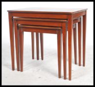 A retro vintage 1970's teak wood trio nest of tables having rectangular tops raised on square
