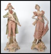 A pair of Royal Dux ceramic figures modelled as a lady and gent. Pink Royal Dux triangles to base.