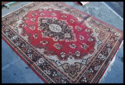 An early 20th century decorative Persian carpet rug having a red ground with geometric pattern.