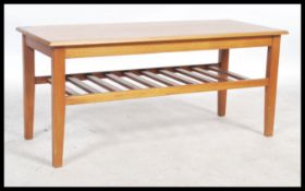 A 20th century retro teak coffee table, with a rectangular overhanging top raised on shaped supports