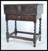 A 17th century Jacobean oak bible box having carved scrolls with grotesque mask. Raised on a later