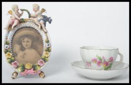 A 19th century Meissen porcelain hand painted cup and saucer along with a Sitzendorf cherub