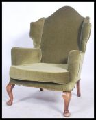 A mid 20th century Antique revival  Parker Knoll wingback armchair raised on cabriole legs with