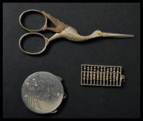 A silver miniature abacus pendant along with a pair of crane bird vanity scissors and a St