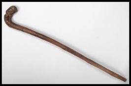 A 19th century bamboo walking stick cane. The handle carved as a dog eating a bird. Please see