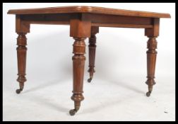 A late 19th / early 20th century mahogany windout dining table, with an additional leaf and winder
