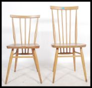 An Ercol beech and elm high back spindle back dining chair along with a near matching smaller