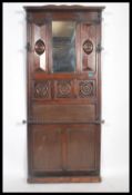 An early 20th century Edwardian oak wall mounted hall stand, having bevelled mirror inset, panel