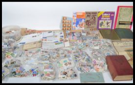 A collection of kiloware loose stamps and stamp albums, many loose stamps and stamps in albums