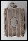 A Victorian hallmarked silver vinaigrette of shaped rectangular form with overall engine turned