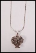 A silver three section locket in the form of the wings of peace complete with silver chain having