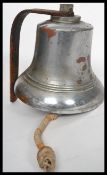 A vintage 20th century polished steel and bronze wall mounted bell of large form complete with