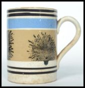 A 19th century Mocha ware tankard having a white ground with blue and black banded decoration and