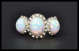A silver and CZ dress ring having three large opals. Weighs 6.6 grams size O.