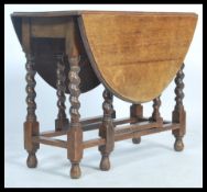 A 1920's solid country oak barleytwist gateleg / drop leaf dining table. Raised on barley twist legs