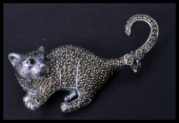 A sterling silver and marcasite brooch in the form of a cat with ruby eye. Pin to verso. Weighs 18.6