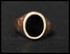 A hallmarked 9ct gold and onyx signet ring set with an oval cut onyx. Hallmarked London. Weight 2.