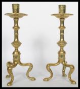 A pair of 19th century Victorian brass candlesticks raised on tripod hairy paw legs with knopped
