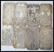 A collection of eight Chinese white metal amulet / scroll weights, cast in relief with various