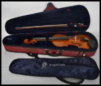 A 20th century students cased Stentor Student II violin together with a mother of pear inlaid bow.