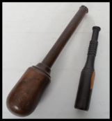Two vintage 20th century turned lignum wood fishing priests of turned form. Measures 35 cm long.
