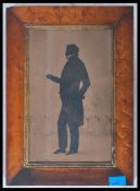A 19th century Georgian framed and glazed silhouette of a gentleman standing before a balustrade,