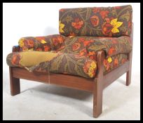 A retro 20th century teak wood show frame armchair being upholstered in a retro floral fabric