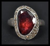 A designer silver and almandine garnet ring having a halo of marcasites. Weighs 20.6 grams size Q.