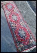 An early 20th century long decorative Persian carpet runner rug having a red ground with geometric
