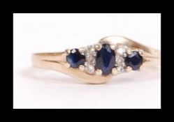 A hallmarked 9ct gold sapphire and diamond crossover ring. Hallmarked London. Weight 3.2g. Size P.