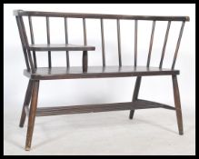 A 20th century retro Ercol style dark elm and beech wood stick back telephone seat, raised shelf