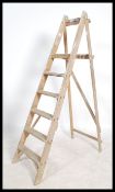 A vintage 20th century Industrial pine wooden step ladder. Of A-frame form having reeded steps and