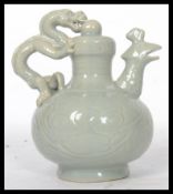 A 20th century Chinese teapot having a green dragon and mythical bird with hole at bottom for