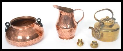 An arts and crafts copper hand beaten jug and bowl along with a brass kettle and two miniature brass