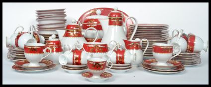 A 20th century Noritake tea service having a red banded border with gilt decoration comprising cups,