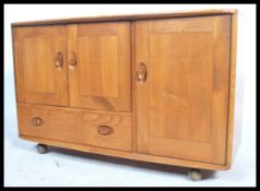 A retro Ercol 20th century elm wood sideboard of small proportions. The sideboard comprising a