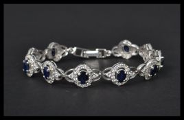 A silver CZ and sapphire panel bracelet having a f