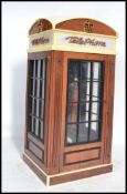 A contemporary telephone in the form a phone box, push button ring dial and an antique style hand